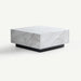 A modern square coffee table with a white marble top featuring gray veining and a contrasting black metal base, shown on a clean off-white background.