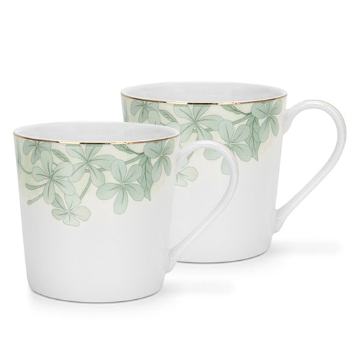 Two white mugs with green leaf patterns on a white background