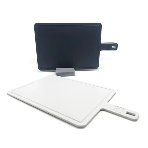 Two cutting boards, one black and one white, on a white background