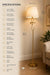A gold floor lamp with a white drum shade is shown in a living room setting with overlaid dimension lines and a specifications list on the left side.