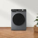 Gray washing machine on a wooden floor with a white wall background