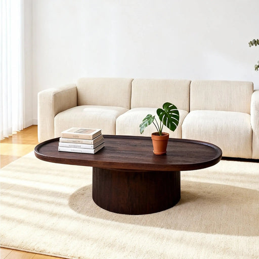 Wooden coffee table with a plant and books in front of a beige sectional sofa.