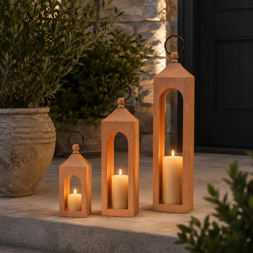 Set of wooden lanterns with candles on a stone surface outdoors.