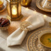 Decorative table setting with a lit lantern, bowl of dates, and patterned plates.
