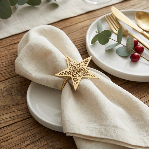 Napkin with a gold star-shaped napkin ring on a wooden table setting.