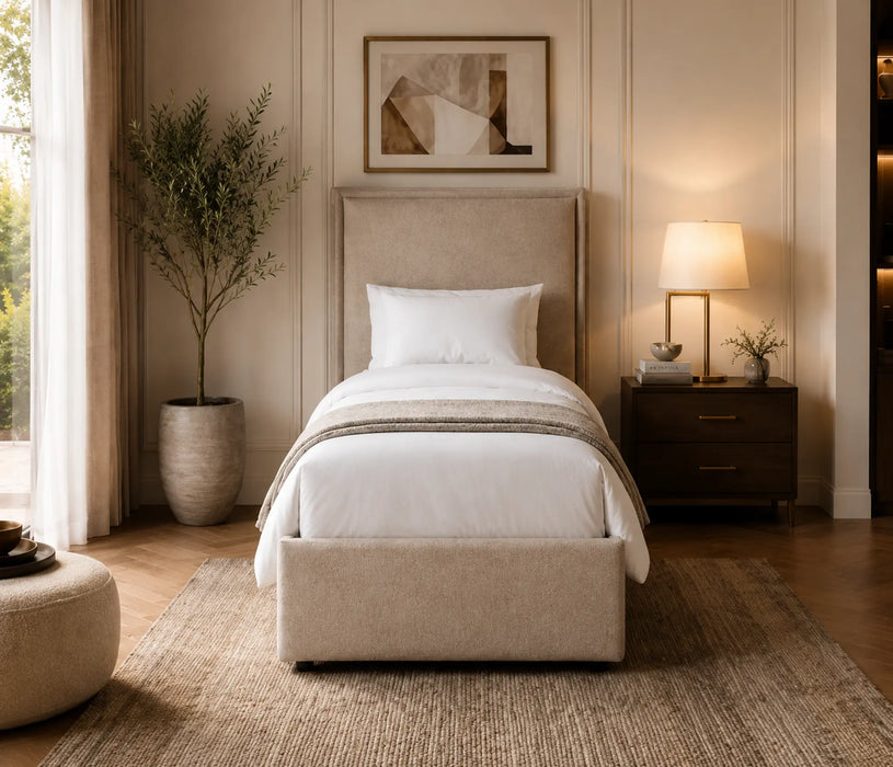 Neatly made bed in a bedroom with a lamp and plant.