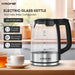 Krome electric glass kettle on a kitchen counter with a cup of tea and honey.