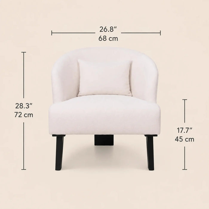 A light blush pink upholstered accent chair with a matching back cushion and black legs, shown with dimension lines and measurements for width, height, and leg depth on a warm beige background.