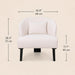 A light blush pink upholstered accent chair with a matching back cushion and black legs, shown with dimension lines and measurements for width, height, and leg depth on a warm beige background.