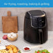 Black air fryer on a kitchen counter with food items around it, featuring text about its functions.