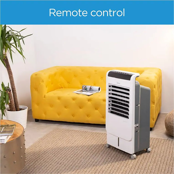 Portable air conditioner in a living room with a yellow sofa and remote control.