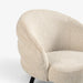 Close-up of a modern upholstered accent chair with a rounded, cloud-like back and seat in a textured beige fabric, set against a clean white background.