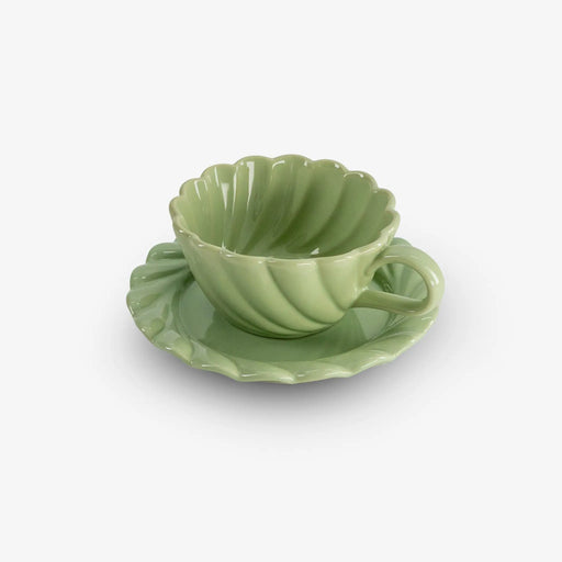 Green ceramic cup and saucer set on a white background