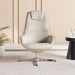 Beige armchair in a modern room with a plant and small table.