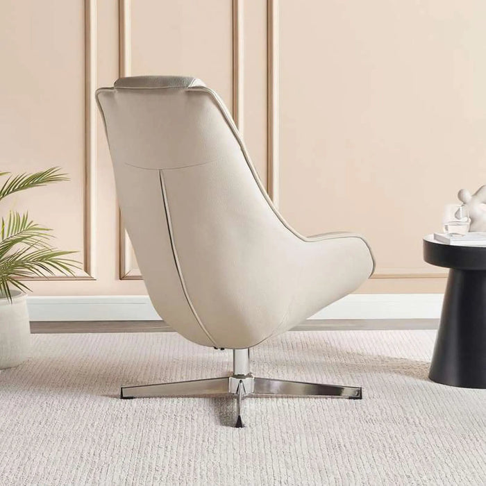 A modern cream-colored leather lounge chair with a chrome star base, styled in a minimalist room with beige paneled walls, a small potted plant, and a black side table.