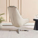 A modern cream-colored leather lounge chair with a chrome star base, styled in a minimalist room with beige paneled walls, a small potted plant, and a black side table.