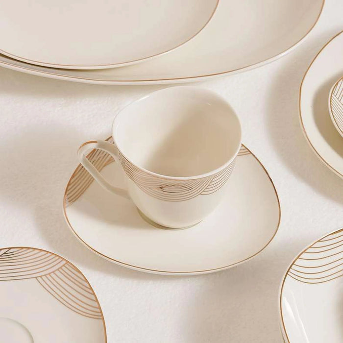 Ceramic cup and saucer set with geometric patterns on a matching plate.