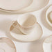 Ceramic cup and saucer set with geometric patterns on a matching plate.