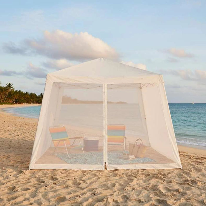 Beige canopy tent on a sandy beach with ocean and sky in the background