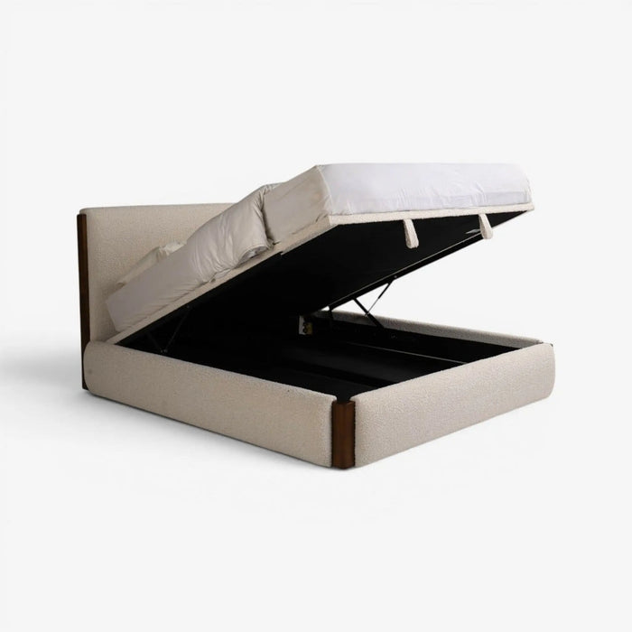 An upholstered lift-up storage bed frame with a mattress on top, shown open against a plain light gray studio background.