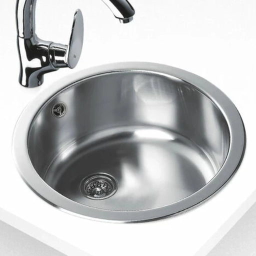 Stainless steel kitchen sink with faucet on a white background