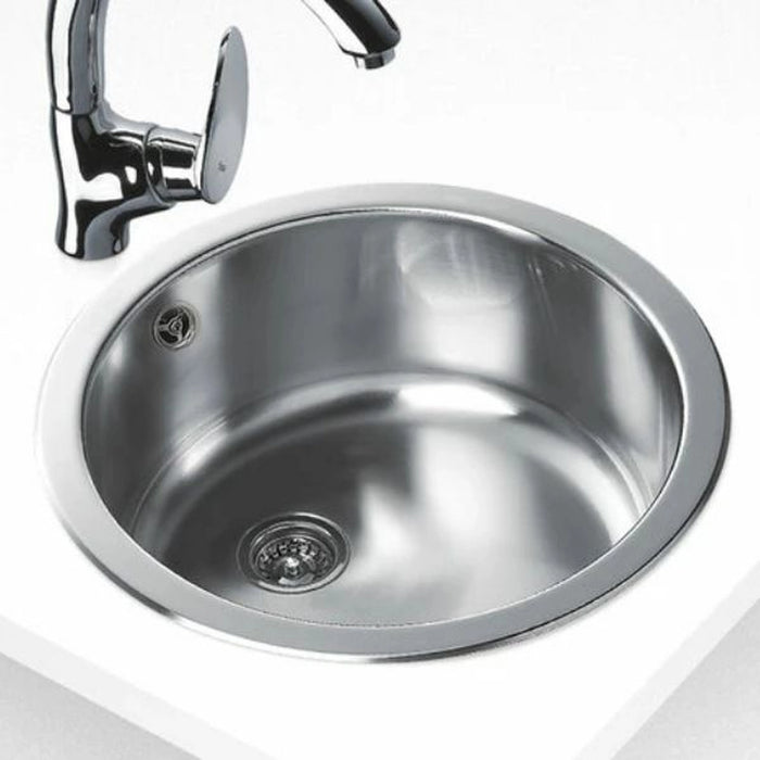 Stainless steel kitchen sink with faucet on a white background