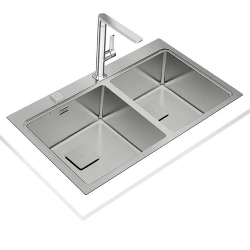 Stainless steel kitchen sink with faucet on a white background