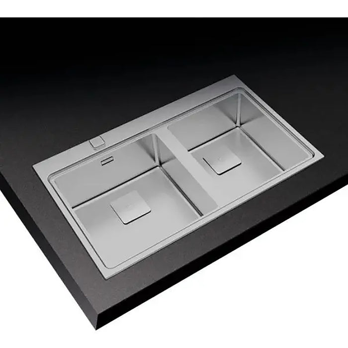 Stainless steel kitchen sink with divided compartments on a black background
